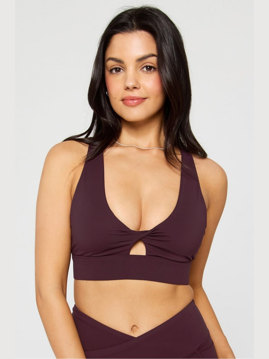 Deep burgundy Fabletics Oasis Twist sports bra with halter neckline, twisted keyhole detail, and ribbed band for medium-impact support