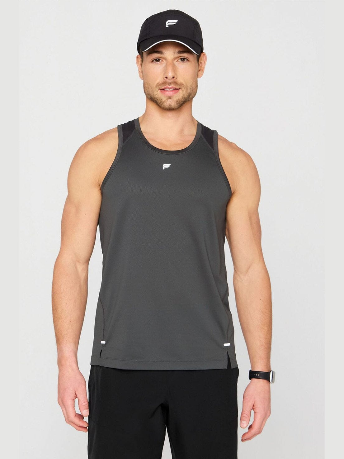 Men's dark gray Fabletics O2 running tank with black shoulder panels, side slits, and moisture-wicking mesh fabric