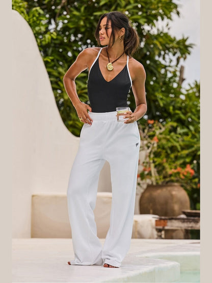 White Fabletics Year Round Terry flare pants with roll-over waistband and hidden drawcord, showing soft textured fabric and relaxed wide-leg fit